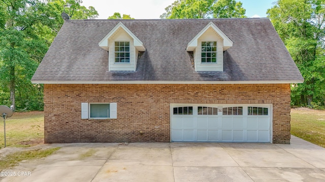 cape cod-style house with brick siding, driveway, a shingled roof, and a garage