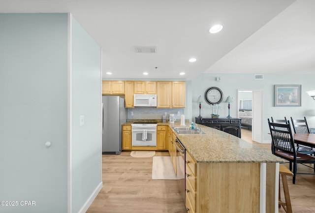 17739 Front Beach Rd Unit 1207W, Panama City Beach, FL 32413 - kitchen featuring a peninsula, light stone counters, visible vents, light brown cabinetry, and appliances with stainless steel finishes