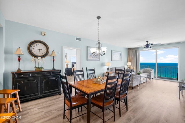 17739 Front Beach Rd Unit 1207W, Panama City Beach, FL 32413 - dining area with light wood-style flooring, visible vents, and ceiling fan with notable chandelier