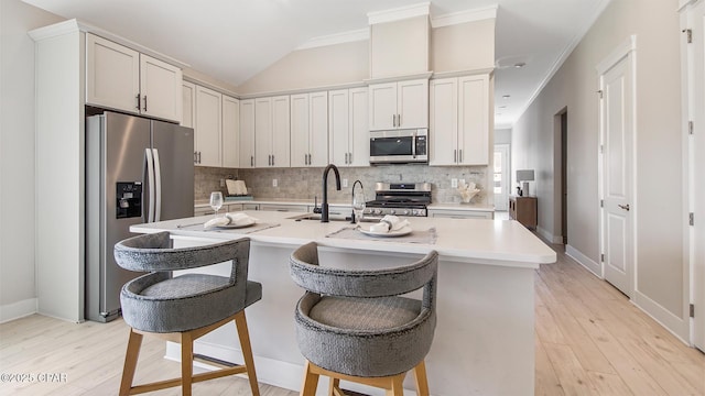 845 Walsonham Dr, Panama City Beach, FL 32407 - kitchen with stainless steel appliances, tasteful backsplash, light countertops, light wood-style floors, and vaulted ceiling