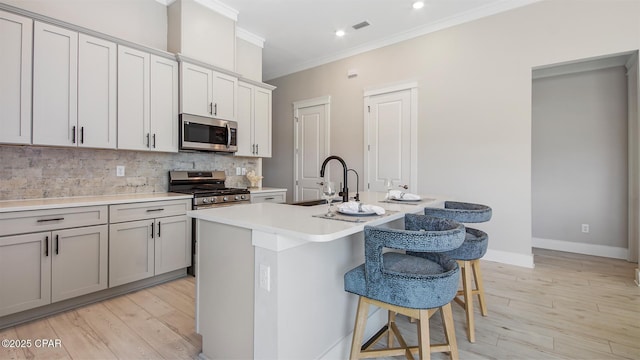 845 Walsonham Dr, Panama City Beach, FL 32407 - kitchen featuring appliances with stainless steel finishes, a sink, a kitchen breakfast bar, crown molding, and decorative backsplash