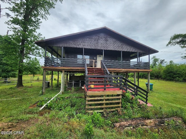 exterior space with stairs, a lawn, and a deck