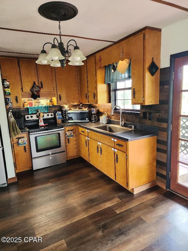 kitchen featuring brown cabinets, stainless steel appliances, dark wood-style floors, and a sink