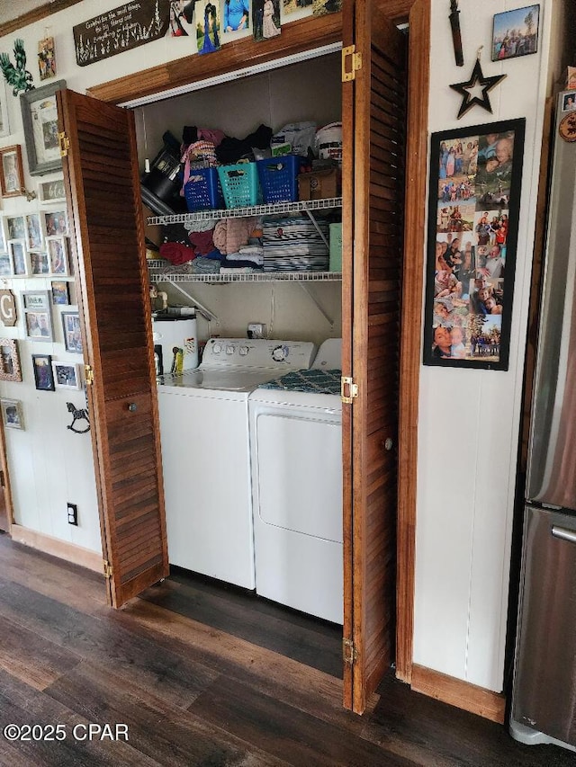 washroom with laundry area, washing machine and dryer, wood finished floors, and water heater