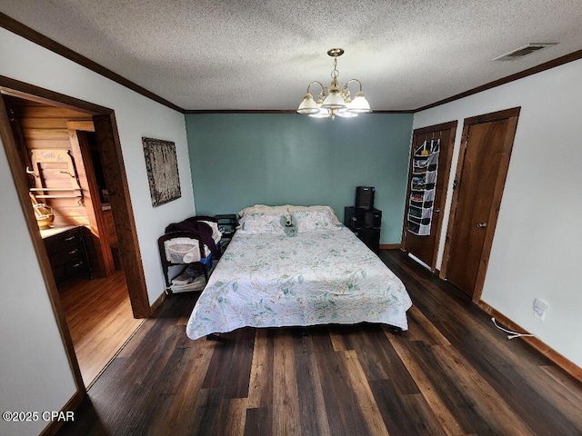bedroom with crown molding, a notable chandelier, a textured ceiling, baseboards, and visible vents