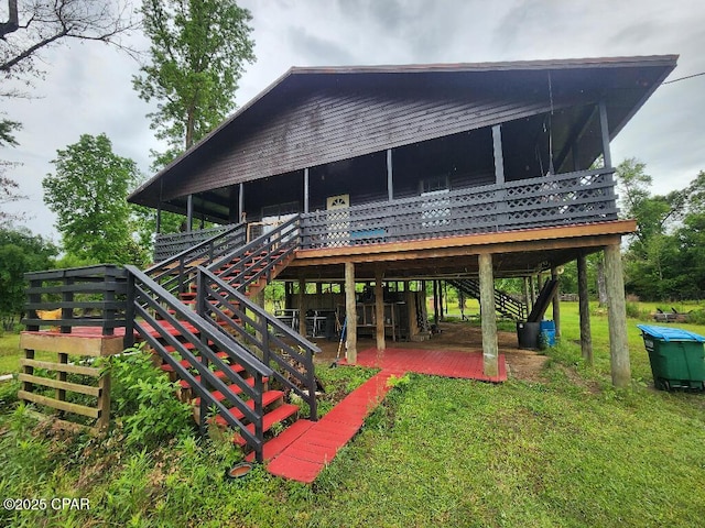 rear view of house with a lawn, a deck, and stairs
