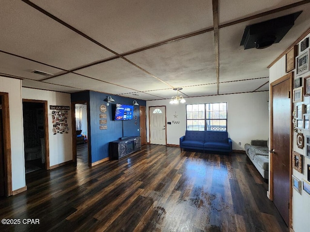 living area featuring baseboards, wood finished floors, and a notable chandelier