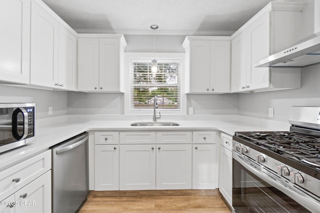 871 2nd St, Chipley, FL 32428 - kitchen with stainless steel appliances, a sink, wall chimney exhaust hood, white cabinetry, and a textured ceiling