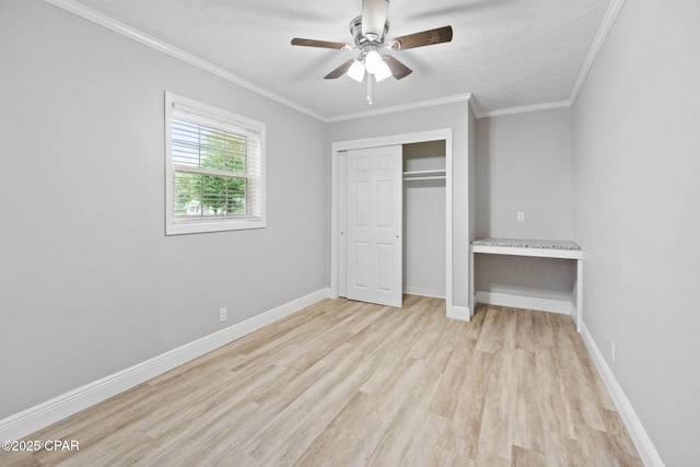 871 2nd St, Chipley, FL 32428 - unfurnished bedroom featuring light wood finished floors, crown molding, a closet, a textured ceiling, and baseboards