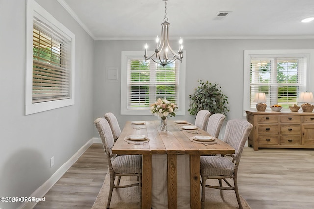 871 2nd St, Chipley, FL 32428 - dining room featuring a chandelier, plenty of natural light, light wood-style floors, crown molding, and baseboards