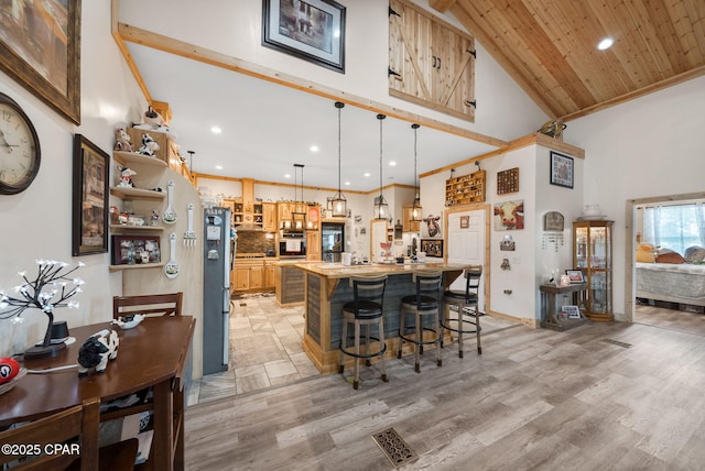2612 NW County Road 274, Fountain, FL 32438 - kitchen with a breakfast bar area, open shelves, high vaulted ceiling, stainless steel appliances, and recessed lighting