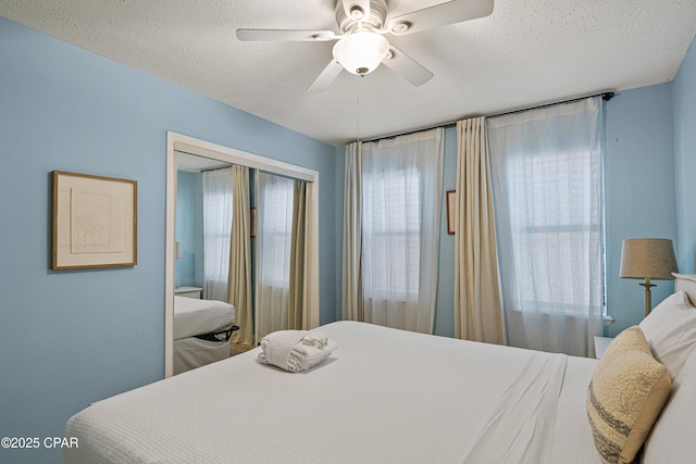 bedroom with a textured ceiling, a closet, and a ceiling fan