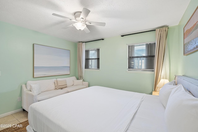 bedroom with light tile patterned floors, a textured ceiling, and a ceiling fan