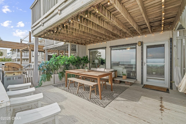 wooden deck with area for grilling and outdoor dining space