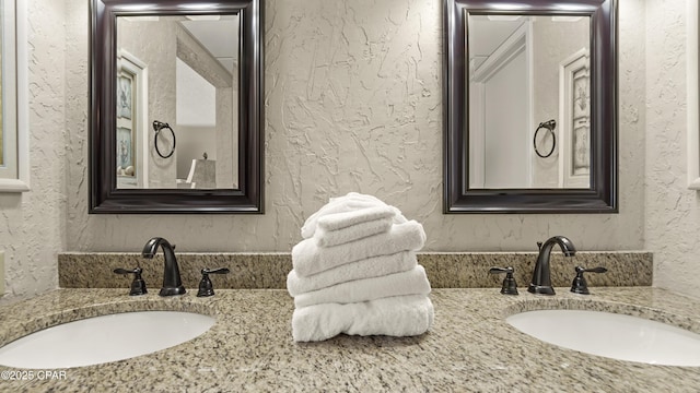 bathroom with a textured wall and vanity