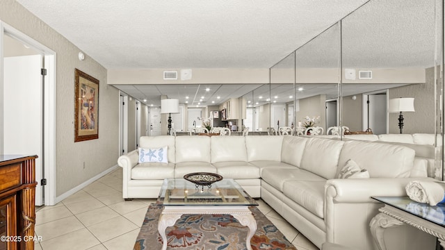 living area with light tile patterned flooring, baseboards, a textured ceiling, and recessed lighting