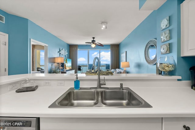 kitchen featuring light countertops, a sink, white cabinetry, ceiling fan, and dishwasher