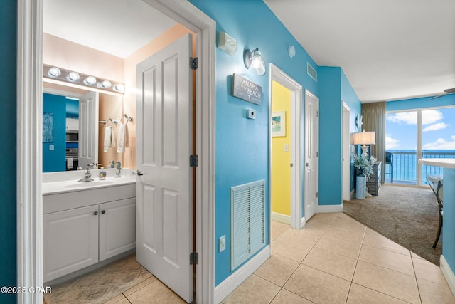 bathroom featuring baseboards, visible vents, tile patterned flooring, and vanity