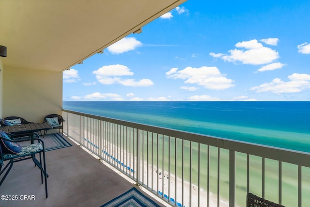 balcony featuring a water view and a view of the beach
