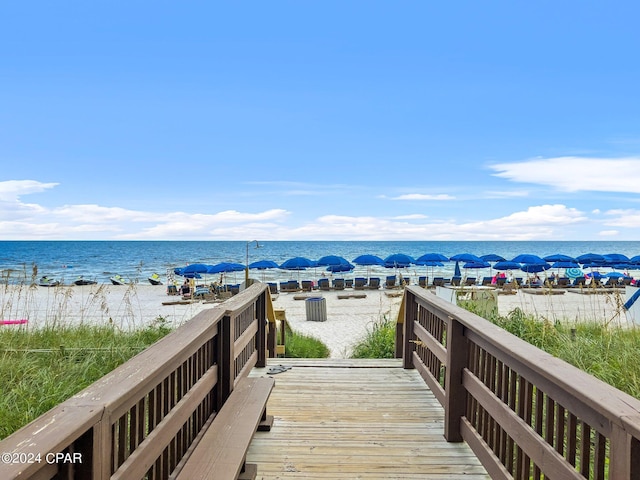 view of property's community featuring a water view and a beach view