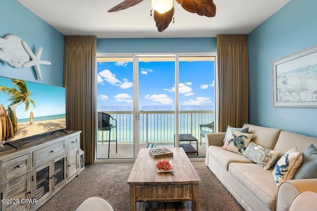 carpeted living room featuring a water view and a ceiling fan