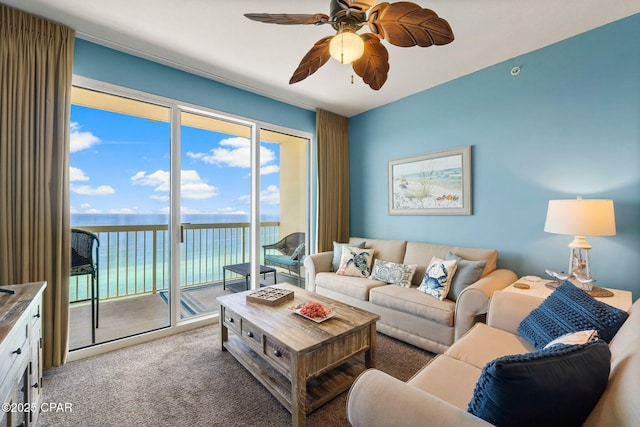 carpeted living area featuring ceiling fan and a water view