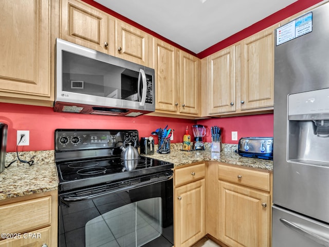 kitchen featuring light stone countertops, light brown cabinets, and appliances with stainless steel finishes