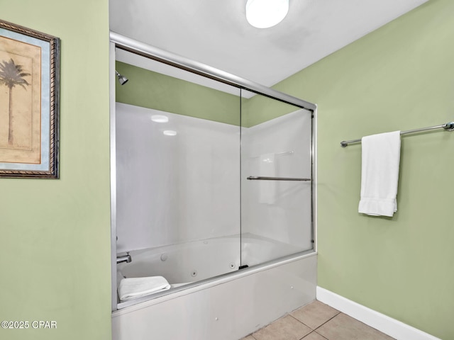 bathroom with tile patterned flooring, baseboards, and bath / shower combo with glass door
