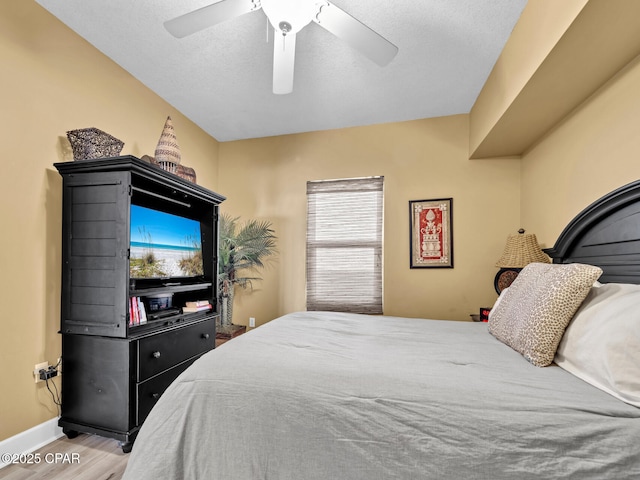 bedroom featuring a ceiling fan, wood finished floors, and baseboards