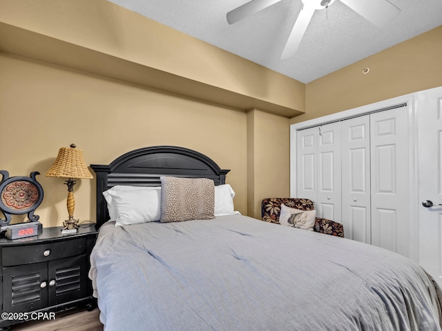 bedroom featuring a textured ceiling, a closet, a ceiling fan, and wood finished floors