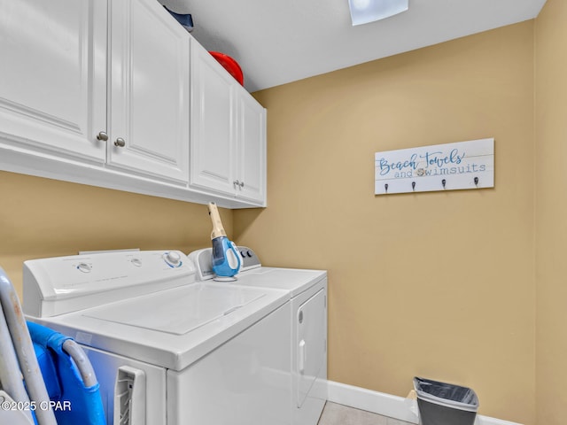 laundry area featuring cabinet space, independent washer and dryer, light tile patterned floors, and baseboards