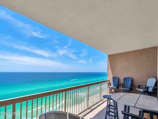 balcony with a water view and a beach view