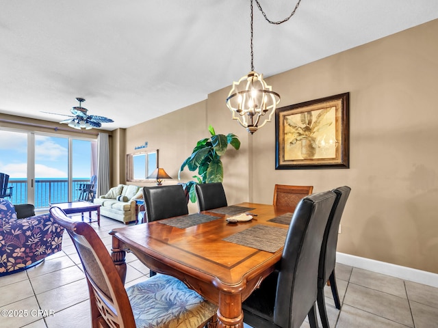 dining area featuring ceiling fan with notable chandelier, baseboards, and light tile patterned floors