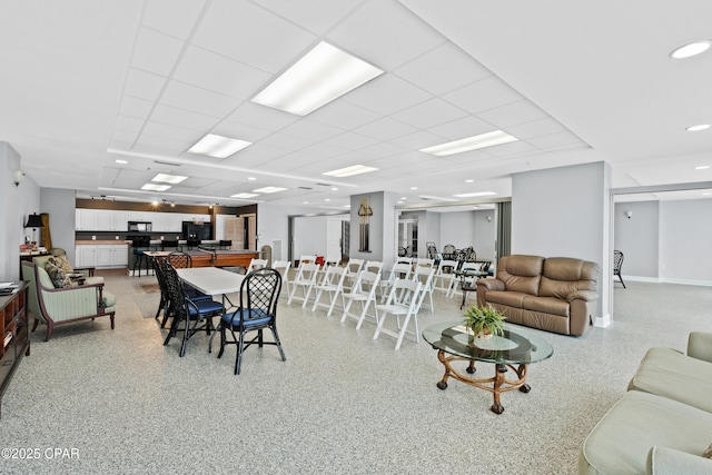 dining area featuring light speckled floor and a paneled ceiling