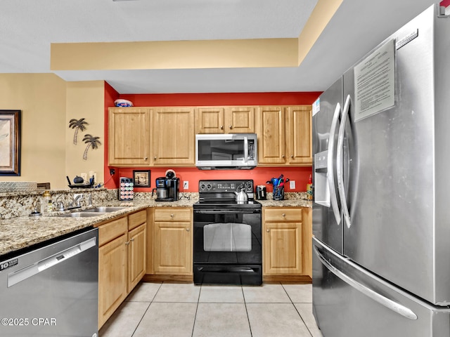 kitchen with light tile patterned floors, a sink, light brown cabinets, light stone countertops, and appliances with stainless steel finishes