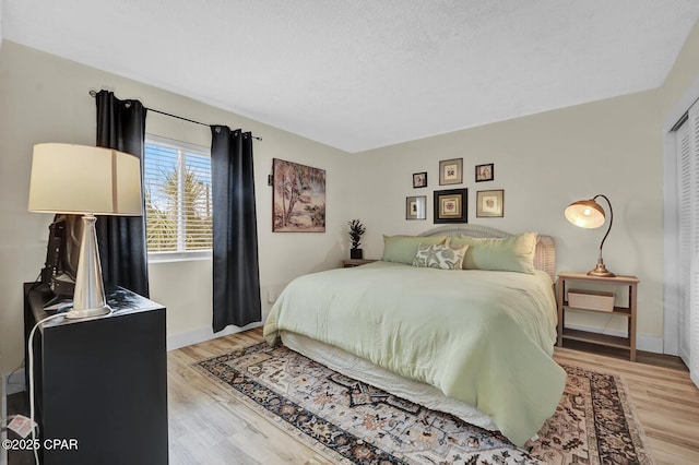 bedroom featuring light wood-style flooring and baseboards
