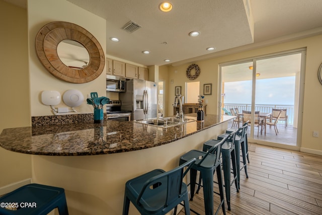 kitchen with recessed lighting, visible vents, a sink, a peninsula, and stainless steel appliances
