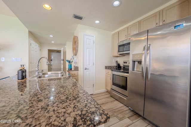 kitchen featuring a sink, stainless steel appliances, wood tiled floor, visible vents, and recessed lighting