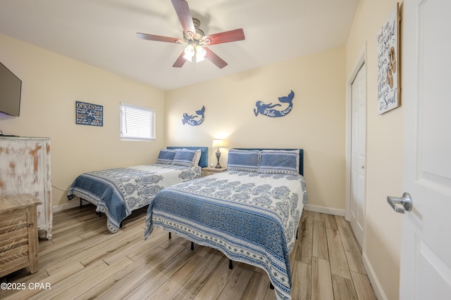 bedroom featuring a closet, wood finished floors, baseboards, and ceiling fan