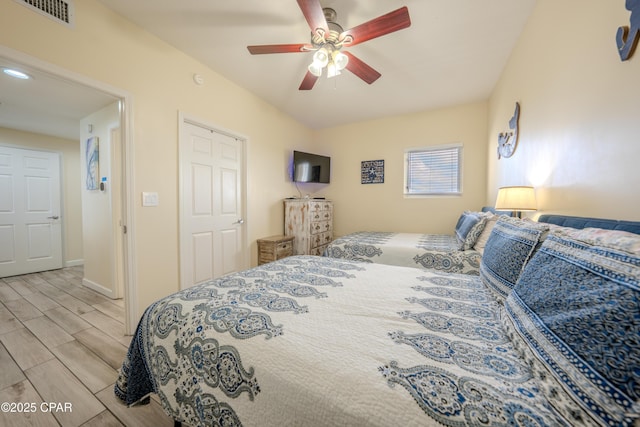 bedroom featuring ceiling fan, visible vents, baseboards, and wood finish floors