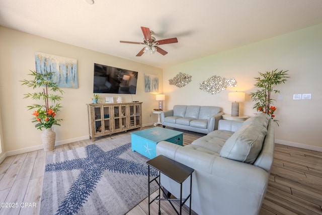 living area with wood finished floors, baseboards, and ceiling fan
