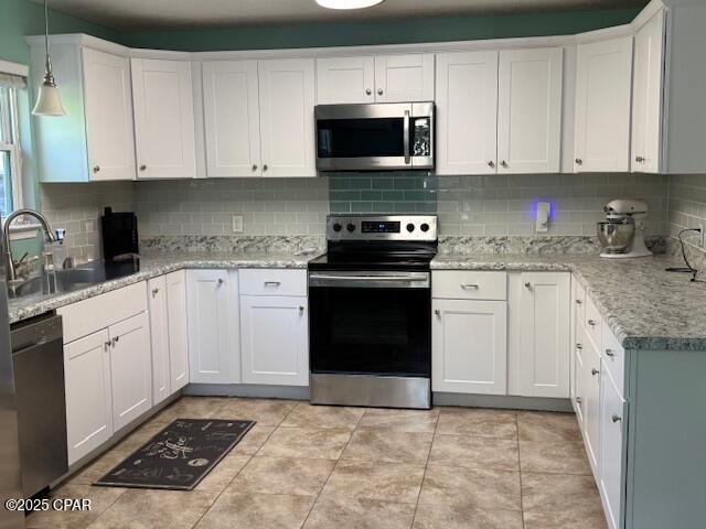 25 Wood Ave, Panama City, FL 32404 - kitchen with backsplash, stainless steel appliances, and white cabinets