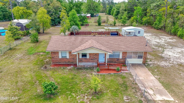 215 Tates Ln, Southport, FL 32409 - view of front of home with fence, brick siding, driveway, a front lawn, and a shingled roof