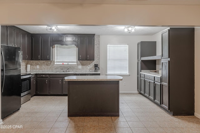 215 Tates Ln, Southport, FL 32409 - kitchen with freestanding refrigerator, a wealth of natural light, tasteful backsplash, and electric stove