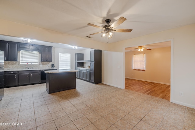 215 Tates Ln, Southport, FL 32409 - kitchen with visible vents, light countertops, a ceiling fan, dark cabinets, and a kitchen island