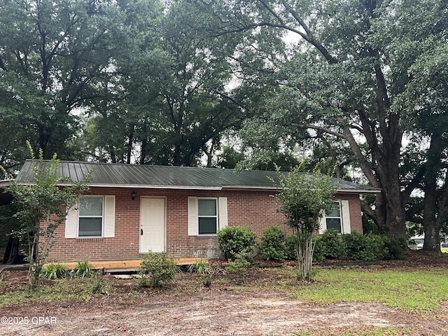 single story home with brick siding and metal roof