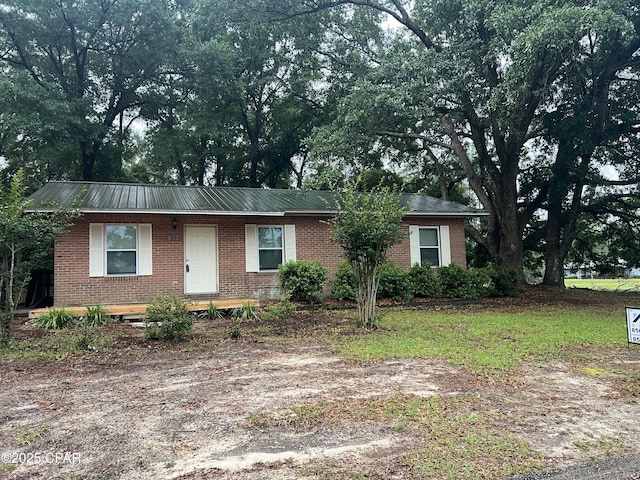 single story home with brick siding and metal roof