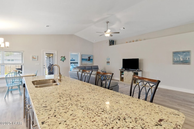 4717 Maegans Ridge Rd, Panama City, FL 32404 - kitchen with light wood finished floors, a sink, open floor plan, vaulted ceiling, and a center island with sink