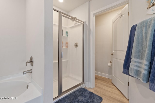 4717 Maegans Ridge Rd, Panama City, FL 32404 - full bathroom with a bathing tub, wood finished floors, baseboards, and a shower with shower door