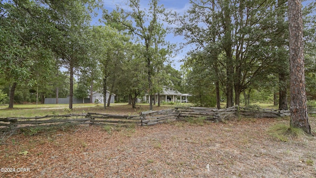 view of yard featuring an outdoor structure and fence